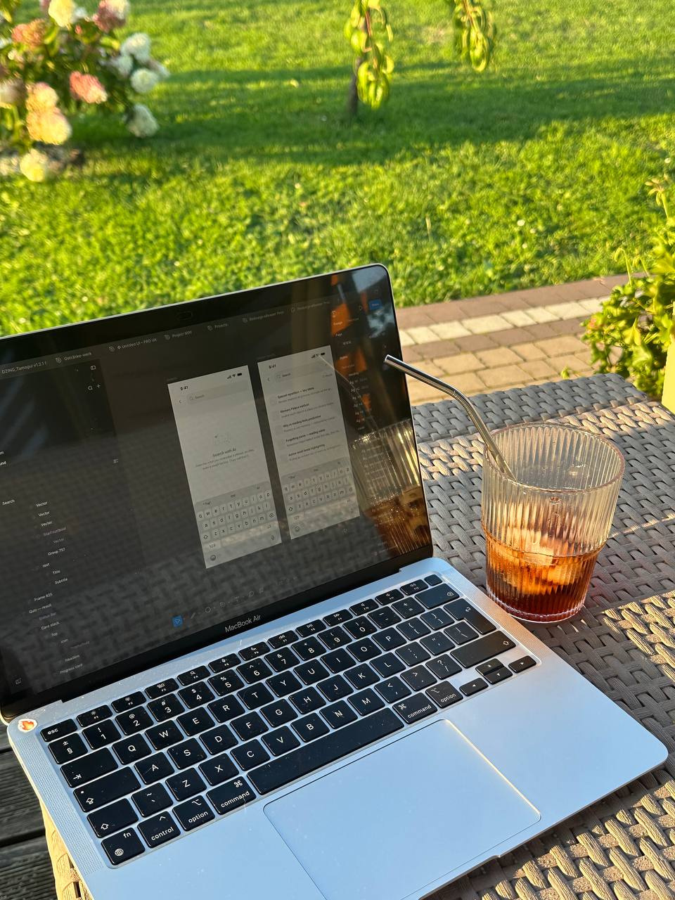 Laptop with Fluxo app screens in progress on a garden table at sunset